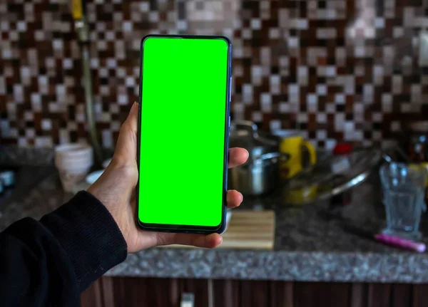 厨房里拿着绿色屏幕手机的女人 把未洗净的盘子放在后面 模拟图像 复制空间 — 图库照片