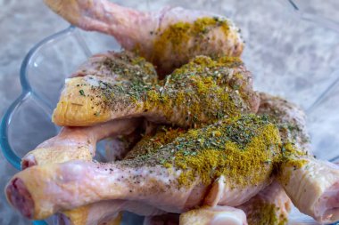 Çeşitli baharatlarla karıştırılmış çiğ tavuk bacağı. Pişmemiş tavuk budu pişirilmeye hazır..