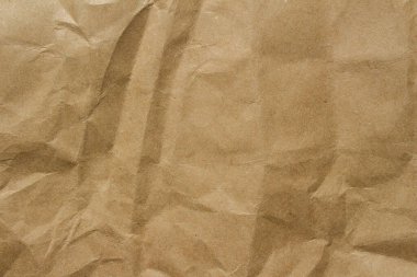 Brown crumpled kraft paper texture with deep folds and creases