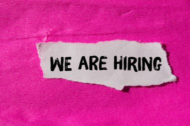 We are hiring message written on ripped torn paper background. Conceptual We are hiring symbol. Copy space.