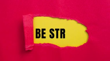 Be Strong message written on ripped torn paper background. Conceptual Be Strong symbol.