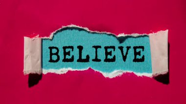 Believe message written on ripped torn paper background. Conceptual Believe symbol.