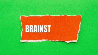 Brainstorming message written on ripped torn paper background