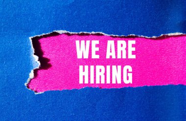 We are hiring message written on ripped torn paper background. Conceptual We are hiring symbol. Copy space.