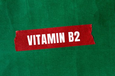 Yırtılan kağıt arkaplanda B2 vitamini mesajı var. Kavramsal B2 vitamini sembolü. Boşluğu kopyala.