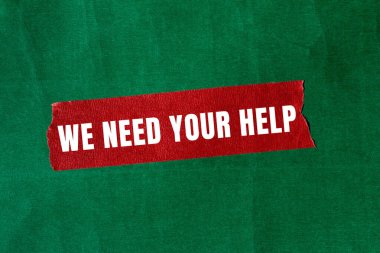 We need your help message written on ripped torn paper background. Conceptual We need your help symbol. Copy space.