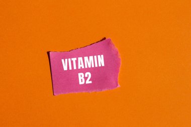 Yırtılan kağıt arkaplanda B2 vitamini mesajı var. Kavramsal B2 vitamini sembolü. Boşluğu kopyala.