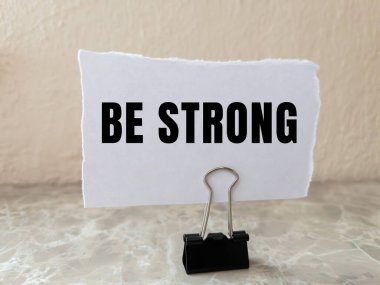 Yırtılan kağıdın arkasına güçlü bir mesaj yaz. Kavramsal Güçlü Ol sembolü. Boşluğu kopyala.