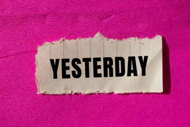 Yesterday message written on ripped torn paper background. Conceptual Yesterday symbol. Copy space.