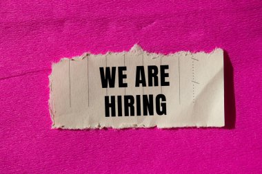 We are hiring message written on ripped torn paper background. Conceptual We are hiring symbol. Copy space.