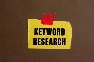 Keyword research message written on ripped torn paper background. Conceptual Keyword research symbol. Copy space.