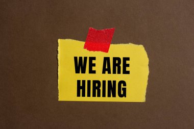 We are hiring message written on ripped torn paper background. Conceptual We are hiring symbol. Copy space.
