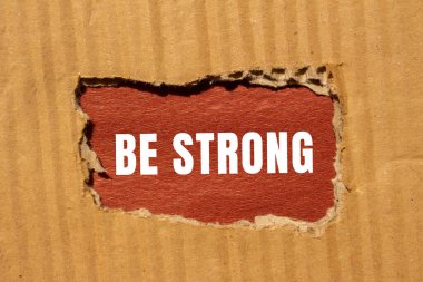 Yırtılan kağıdın arkasına güçlü bir mesaj yaz. Kavramsal Güçlü Ol sembolü. Boşluğu kopyala.