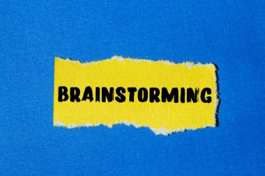 Yırtık kağıt arkaplanına yazılan beyin fırtınası mesajı. Kavramsal Beyin Fırtınası sembolü. Boşluğu kopyala.