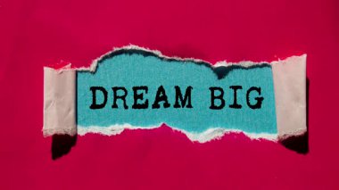 Dream Big message written on ripped torn paper background. Conceptual Dream Big symbol.