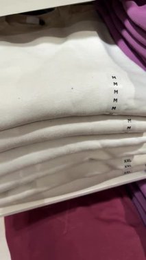 Katlanmış pamuk t-shirtler düzgünce bir rafa dizilmişti.