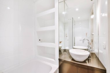 Küveti ve aynası olan modern bir banyo.