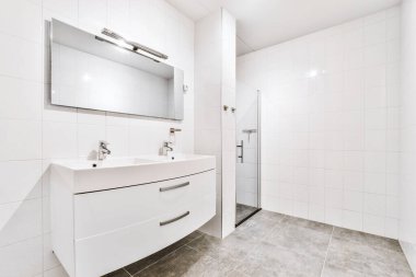 Beyaz fayanslı duvarlı banyo.