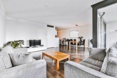 Dinlenme odası ve yemek alanları olan geniş modern bir oda.