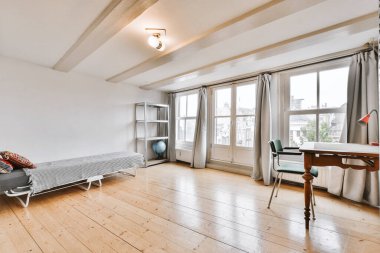 Çalışma masası ve kanepesi olan geniş bir oda.