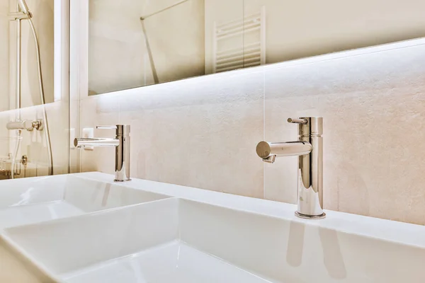 Glanzende kranen over wastafels in de badkamer — Stockfoto