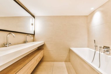 Modern banyoda küvet ve çift lavabo.