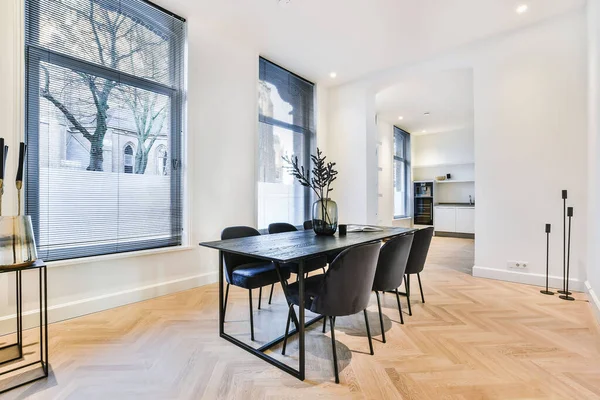 Mesa de jantar preta em sala branca com cozinha — Fotografia de Stock