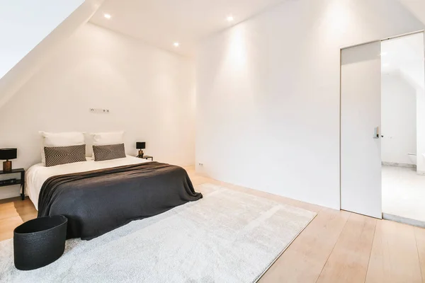 Современный мансардный дизайн спальни с большим окном — стоковое фото