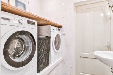 Lavabosu ve ahşap rafı olan çamaşır odası.