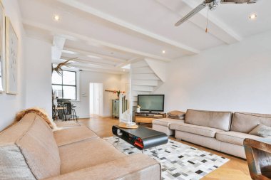 Geniş ışıklı oturma odasında rahat koltuklar