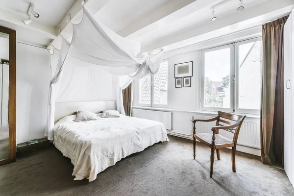 Cozy white bedroom with canopy and soft floor — Stockfoto