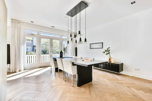 Dining table with pendant lamps in house