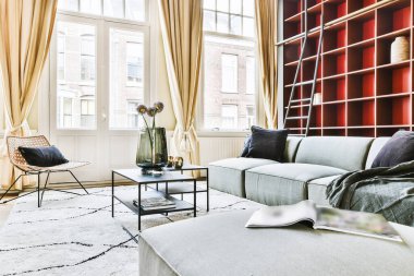 Odada gri kanepe, duvarda raflar