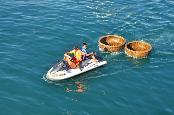 Nha Trang, Vietnam - July 14, 2015: A rescue canoe is towing two basket boat in the sea — Stock Photo, Image