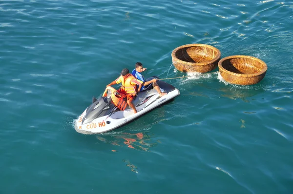Nha trang, Vietnam - 14. Juli 2015: Ein Rettungskanu schleppt zwei Korbboote ins Meer — Stockfoto
