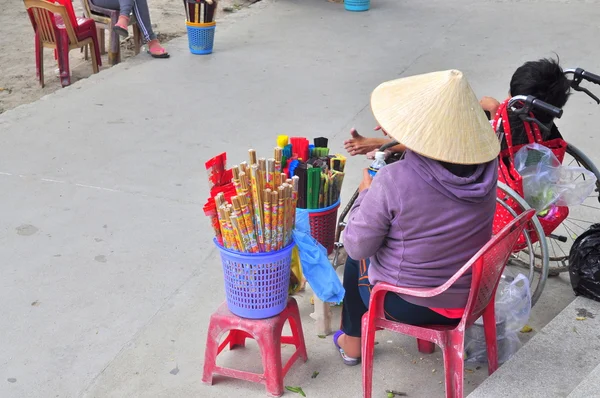 Nha Trang, Vietnam - 7 de febrero de 2016: Una anciana vende incienso en una pagoda de Vietnam — Foto de Stock