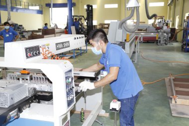 Long An, Vietnam - 11 Temmuz 2016: İşçiler ihracat için bir odun fabrikasında çalışıyor
