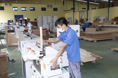 Long An, Vietnam - 11 Temmuz 2016: İşçiler ihracat için bir odun fabrikasında çalışıyor