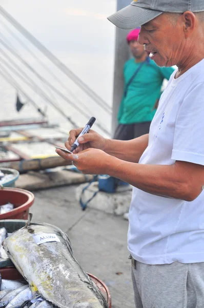 Генерал Сантос, Филиппины - 5 сентября 2015 г.: Рыбак считает тунца с рыболовного судна в морском порту — стоковое фото