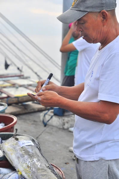 General Santos, Filipinas - 5 de setembro de 2015: Pescador está contando atum de barco de pesca no porto — Fotografia de Stock