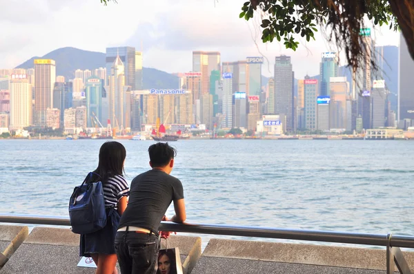 Hong Kong, China - 9 de septiembre de 2015: Una joven pareja está de pie en el puerto mirando a la ciudad — Foto de Stock