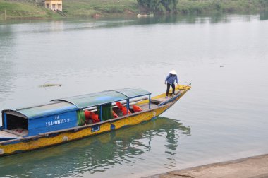 Quang Binh, Vietnam - 23 Ekim 2015: geleneksel yerel tekne turizm için transfer seyahat edenler için bekleyen bir iskelede demirleme