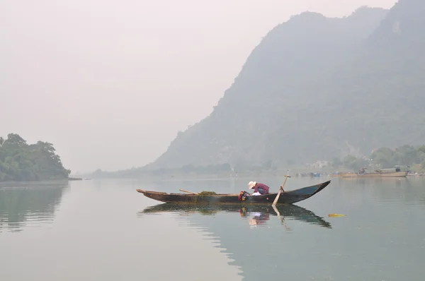 Pescador local está pescando con su pequeño barco en el río Trang An — Foto de Stock
