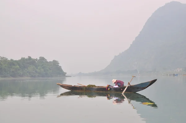 Lokala fiskare fiskar med sin lilla båt på Trang en flod — Stockfoto