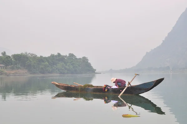 Местный рыбак рыбачит на своей маленькой лодке на реке Транг Ан. — стоковое фото