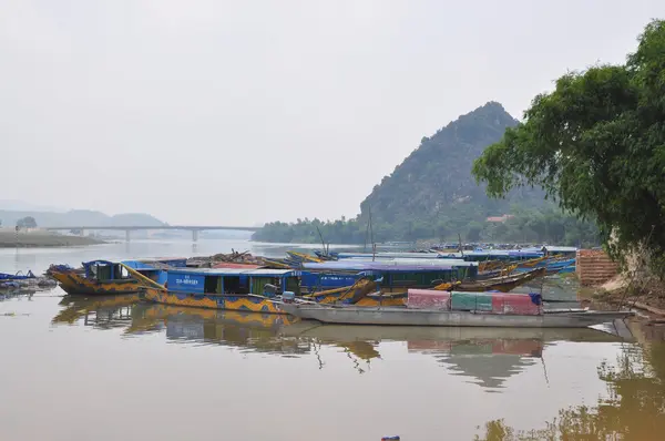 Quang Binh, Vietnam - October 23, 2015: Traditional local boats transfered for tourism are mooring at a pier waiting for travellers — Stock Photo, Image