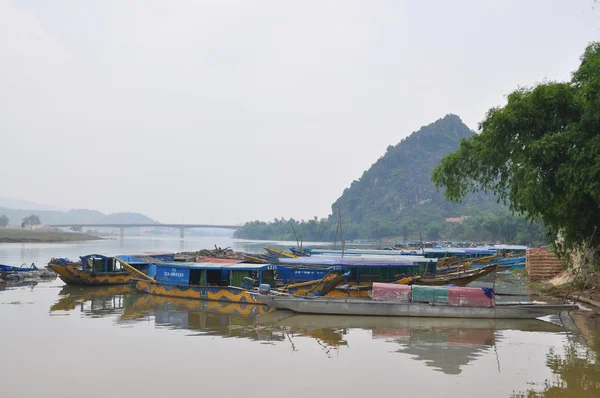 Quang Binh, Vietnam - October 23, 2015: Traditional local boats transfered for tourism are mooring at a pier waiting for travellers — Stock Photo, Image