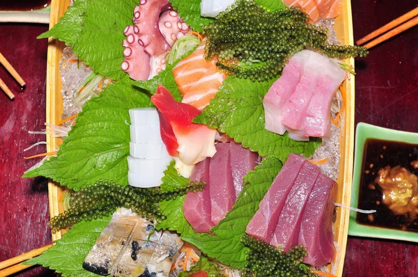 Лодка суши с тунцом, лососем, зеленой икрой и осьминогом — стоковое фото