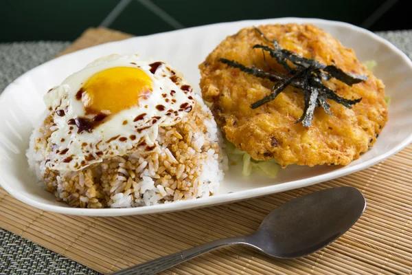 Riz frit avec oeuf sur un bol blanc sur la table — Photo