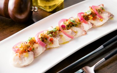 Ahtapot salatası soğan üzerinde beyaz çanak ile